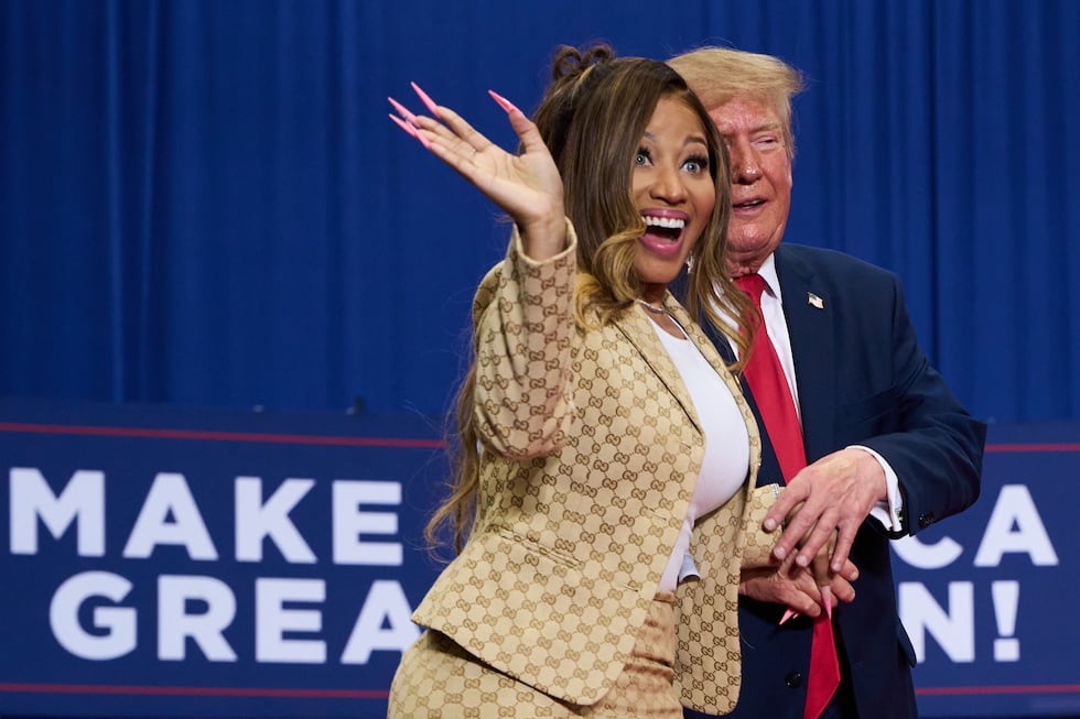 President Donald Trump helps Nicki Minaj to the stage during a campaign rally at McMorran...